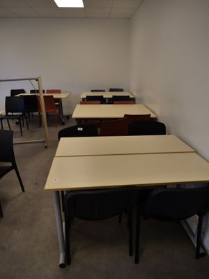 tables and chairs in an empty room with a projector in the background