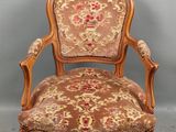 une chaise en bois recouverte d'un tissu à motifs floraux, recouverte, recouverte, recouverte, recouverte, recouverte