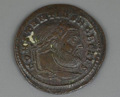 une vieille pièce de monnaie représentant le visage d'un homme, posée sur une table