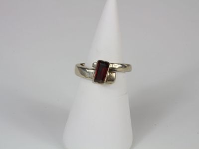 a close up of a ring with a red stone on it