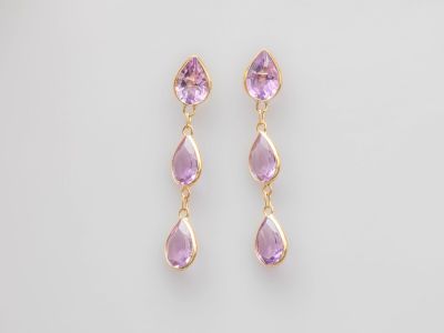 une paire de boucles d'oreilles en améthorate et en or sur fond blanc