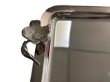 a mirror with a flower on it and a silver handle