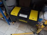 yellow and black tool box sitting on top of a white tiled floor