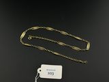 a close up of a gold chain with a tag attached to it