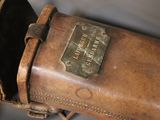 a brown leather case with a metal tag on it