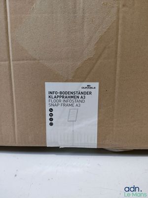 une boîte en carton sur laquelle est collé un autocollant, posée sur une table