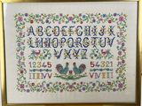 a cross stitched picture of a frame with a picture of a rooster on it