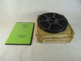 une bobine de film posée sur une boîte à côté d'un livre