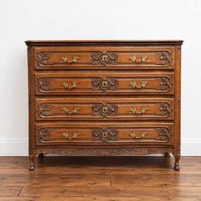 une commode en bois dont les tiroirs sont ornés de sculptures élaborées