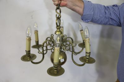 un homme qui tient un lustre à la main