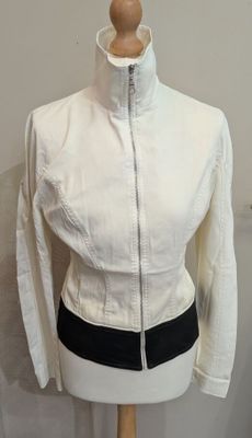un mannequin vêtu d'une veste blanche, posé sur un socle