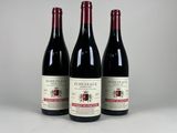 trois bouteilles de vin rouge posées côte à côte sur une table