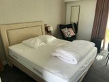 a bed with a white comforter and a chair in a room
