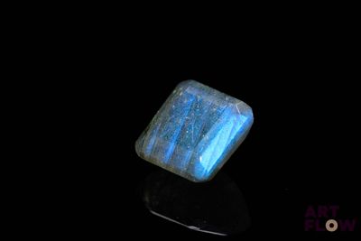 a close up of a blue and white stone on a black surface