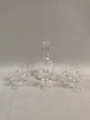 des bouteilles et des verres sont alignés sur une table à fond blanc