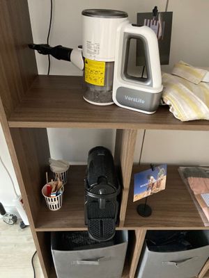 a shelf that has a coffee maker and other items on it