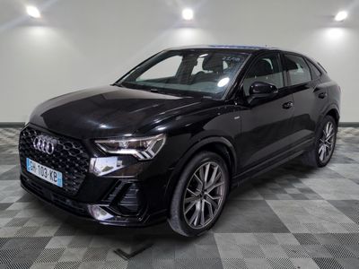 un SUV Audi noir garé sur un sol à damier dans un showroom