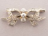 une image représentant une broche en forme de nœud en or sertie de diamants