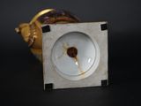 a small white vase with a brown stain on it