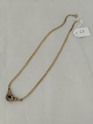 a gold necklace with an evil eye charm on it