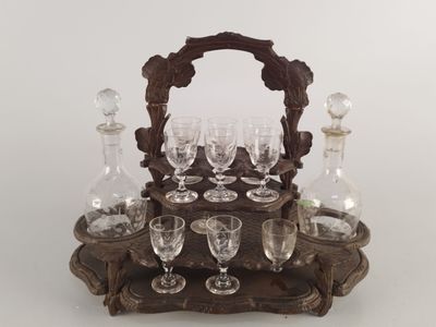 un plateau en bois sur lequel sont posés des verres à vin et des carafes
