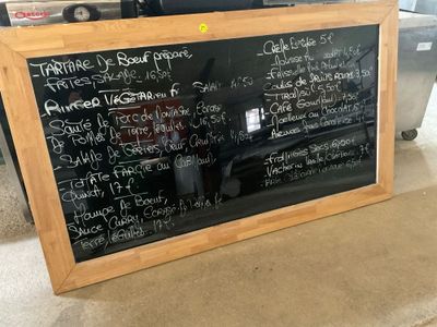 a blackboard with writing on it sitting on the floor