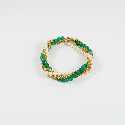 un gros plan d'un bracelet vert et blanc posé sur une surface blanche