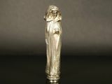 an old silver figurine of a woman with a veil on her head