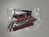 quatre stylos dans un sachet transparent posé sur une table