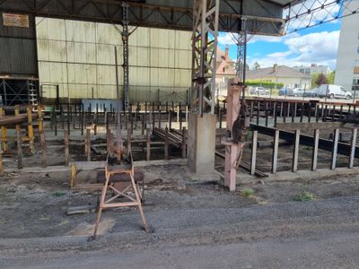 une chaise rouillée posée au milieu d'une gare de triage