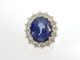 gros plan d'une bague en saphir bleu et diamant sur une surface blanche