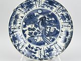 blue and white plate with a bird and flowers on it
