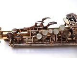 a close up of a saxophone on a white surface
