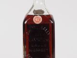 an old bottle of whiskey sitting on top of a white surface