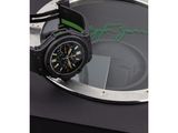 the watch is black and green with a black strap around it