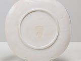 a white plate on a stand on a table