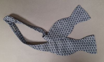 bow tie with a blue and white pattern on a tan background