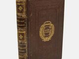 un livre marron orné d'un emblème doré