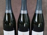 trois bouteilles de champagne posées côte à côte sur une table