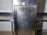 a stainless steel refrigerator sitting in a kitchen next to a table