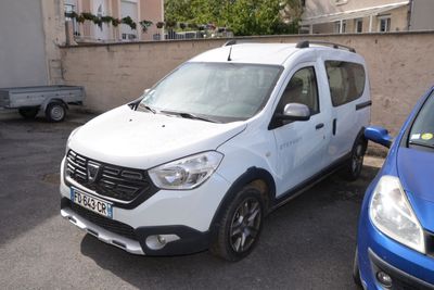 une camionnette blanche garée à côté d'une voiture bleue sur un parking