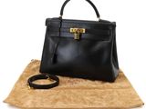 a black leather handbag sitting on top of a brown blanket