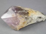 quartz crystal on a rock on a gray surface