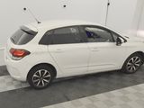 a picture of a small white car parked in a garage
