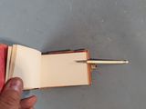 a person holding a pen and a book with a pen in it