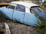 an old car that is sitting in the grass