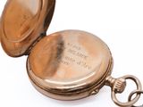 a pocket watch that is sitting on a white surface