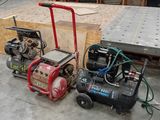 deux compresseurs d'air posés par terre dans un garage