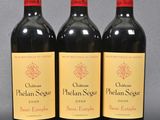 three bottles of red wine sitting on top of a table