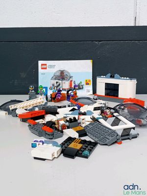 un tas de Lego posé sur une table à côté d'une boîte de Lego